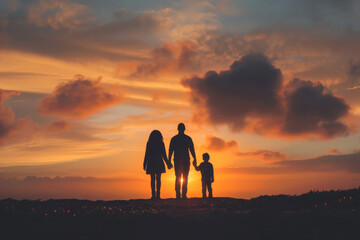 Silhouette of family holding hands at sunset in nature
