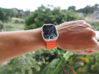 Hand wearing rusty modern smartwatch. Close-up.