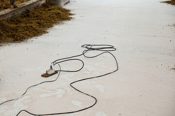 Fototapeta na wymiar A dirty electrical extension cord is lying on the concrete floor.