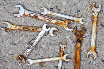 Top view of old rusty wrenches a cement background. Mechanic repair tools.