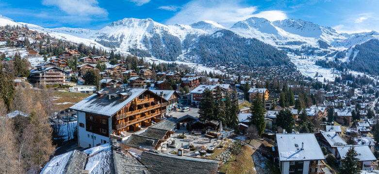 Aerial panoramic view of the Verbier ski resort town in Switzerland. Classic wooden chalet houses standing in front of the mountains. 
