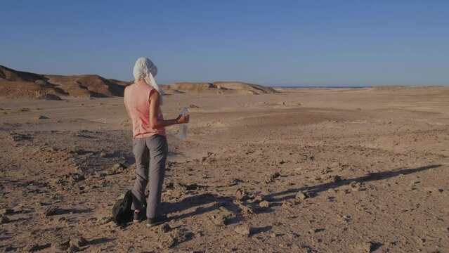 In this video, a woman quenches her thirst amidst the scorching desert of Egypt, highlighting the concept of hot weather as she embarks on a journey through this captivating land.