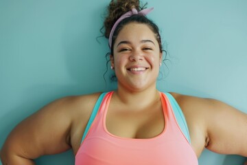 Fototapeta na wymiar Young, positive, smiling overweight woman in sportswear posing in studio