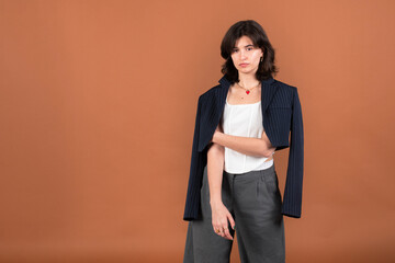 A woman posing with a jacket draped over her shoulders, exuding elegance and sophistication in her...