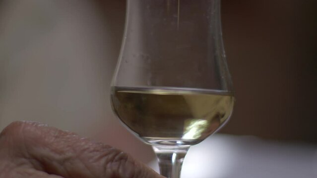 Slow motion of Cachaça being poured on a fancy cup by a Sommelier