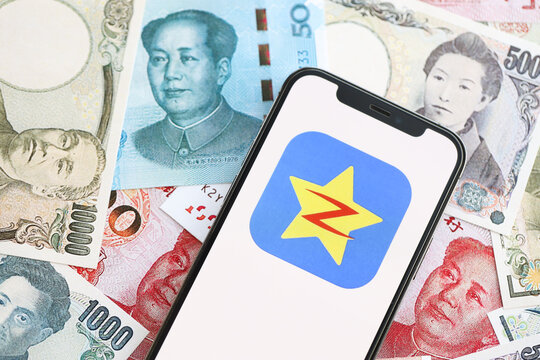 KYIV, UKRAINE - APRIL 1, 2024 Qzone icon on smartphone screen on many asian money bills. iPhone display with app logo with japanese yen and chinese yuan banknotes