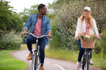 portrait of a mixed couple riding bicycles outdoors