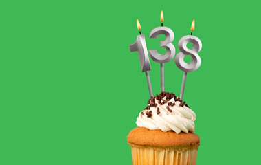 Birthday with number 138 candle and cupcake - Anniversary card on green color background