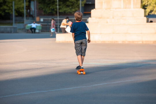 A kid riding a skateboard in a crowded place in the city. stock photo
