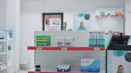 Boxes of prescribed medicine displayed in empty drugstore, awaiting clients to purchase or include under medical coverage. Pharmacy equipped with nutritional products and pharmaceutical drugs.