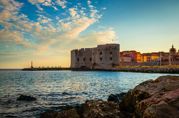 Sunset panoramic view on walls and port of famous old city Dubrovnik, Croatia - 775394983