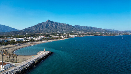 Scenic aerial view of the beach and the mountain behind in Marbella, Spain