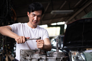 professional male auto mechanic in auto repair shop. technician having automotive job to maintenance or repair automobile in motor garage, business industrial auto car engine.