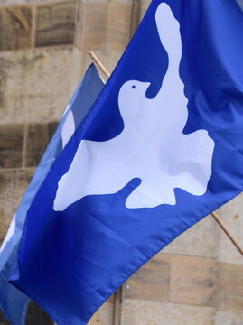 Im Wind wehende blaue Fahne mit wei&szlig;er Friedenstaube