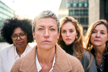Portrait a group of multiracial serious business women of diverse ages looking at the camera with...
