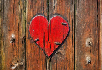 Bright red heart as a symbol of love and friendship on old wooden fence