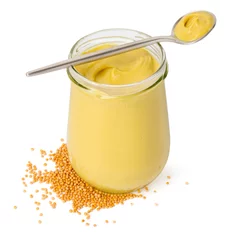Poster Glass jar and spoon of tasty mustard sauce with dry seeds isolated on white © New Africa