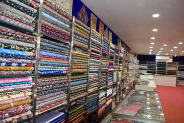 Indian textiles for saris with variety of colors shown in shop at local market