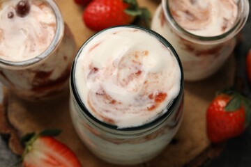 Tasty yoghurt with jam and strawberries on table, above view