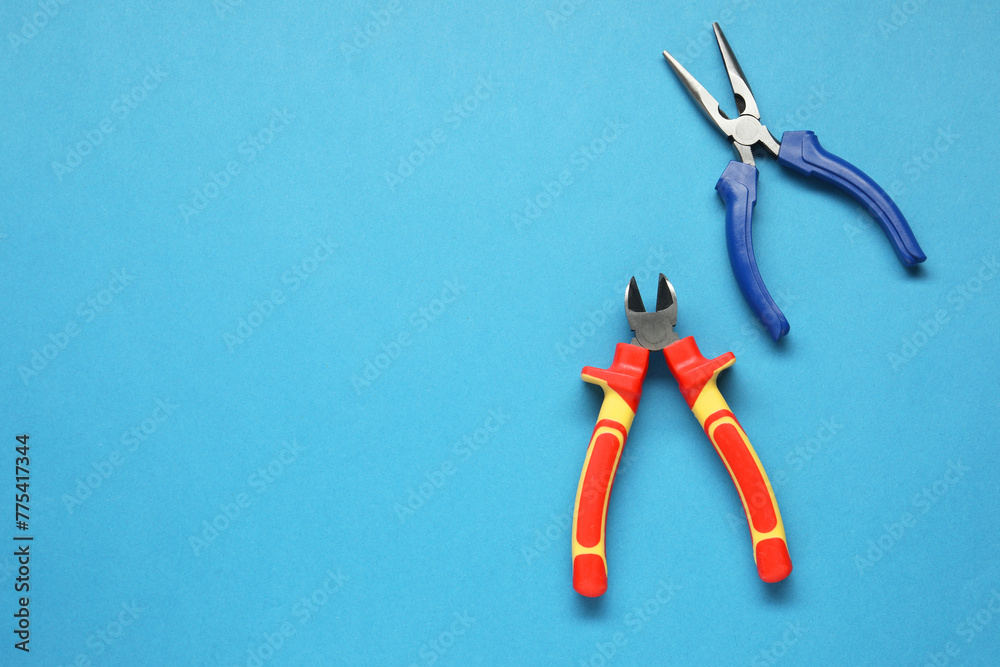 Wall mural pliers on light blue background, flat lay. space for text