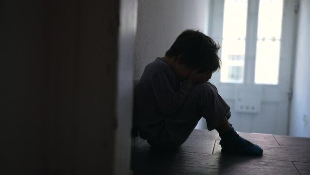 Young Child Experiencing Family Crisis, Sitting Solitarily in Poorly Lit Hallway, Covering Face with Hands to Express Profound Grief and Sorrow