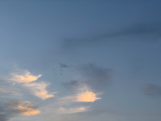 A small group of cloudlets low in blue sky catch the last direct rays of sunset among others fading on a March evening in southwest Florida, for motifs of natural transition