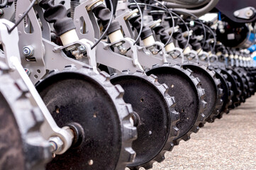 Detailed view of agricultural machinery, focusing on metal discs aligned in a row, showcasing...