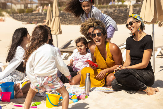 Multiracial families joyfully bonding at the beach - Powered by Adobe