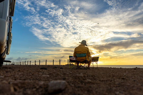 Nomadic Musician Composing by Seaside at Sunset