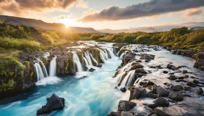 Fotobehang wonderful summer view of bruarfoss waterfall secluded spot with cascading blue waters great sunset in iceland europe beauty of nature concept background © Aedan