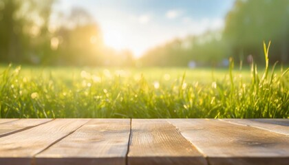 a natural spring garden background of fresh green grass with a bright blue sunny sky with a wooden table to place cut out products on - obrazy, fototapety, plakaty