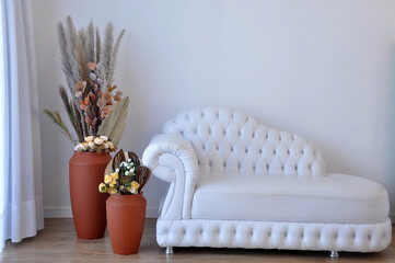 sala com sofa de capitone e vasos decorados com capim dos pampas 
