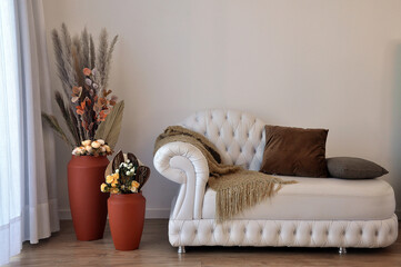 sala com sofa de capitone e vasos decorados com capim dos pampas 