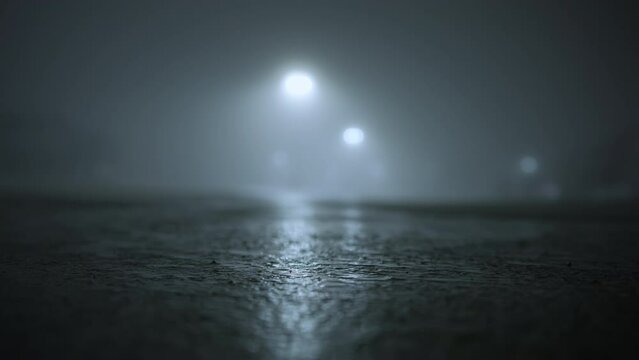 The silhouette of man walking on empty parking lot at fogy night time. Close up