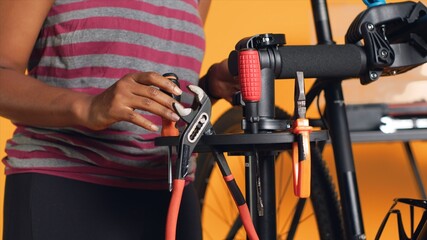 Close up of specialist preparing work tools before starting patching up faulty bicycle parts. Employee arranging screwdriver, pliers and hex wrench on equipment support, handheld camera shot - obrazy, fototapety, plakaty