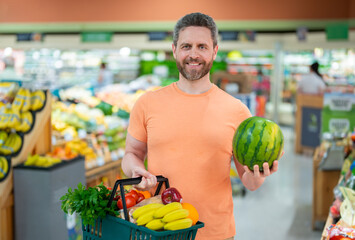 Man with grocery basket shopping at supermarket. Grocery store, shopping basket. Banner with man...