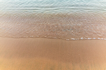 Soft wave of the sea on the sandy beach.
