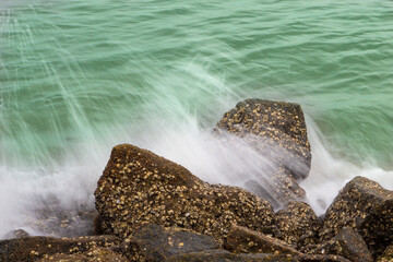 Waves photographed at low speed breaking on the rocks