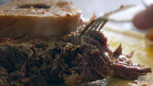Savoring Ossobuco of Close-Up Fork Tear of Tender Meat in macro scene