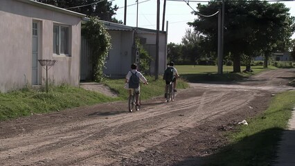 Two Primary School Students Ride Bicycles while Going to School in the Province of Entre Rios, Argentina.  