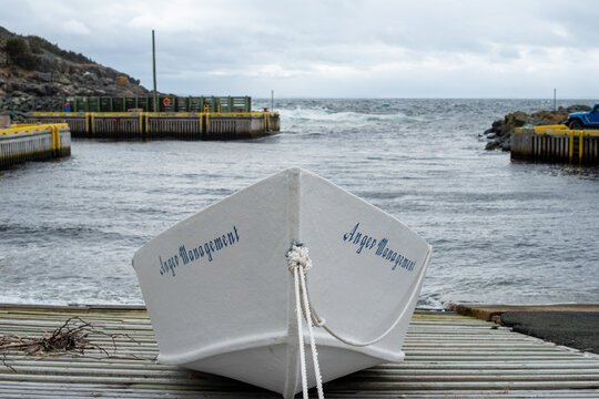 St. John's, Newfoundland, Canada-April 1, 2024: A white open boat with Anger Management written with blue paint on the side of the boat. The vessel is on a wooden slipway in a small harbour.