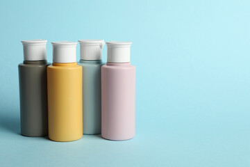 Cosmetic travel kit on light blue background. Bath accessories. Space for text