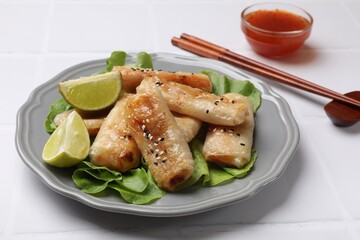 Tasty fried spring rolls served on white table, closeup