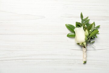 Wedding stuff. Stylish boutonniere on white wooden table, top view. Space for text