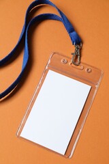 Blank badge with string on orange background, top view