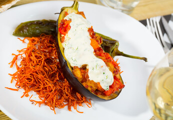 Stuffed eggplant with vegetable stew in sour cream sauce served on plate - Powered by Adobe