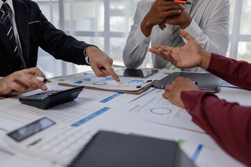 Group of confident business people point to graphs and charts to analyze market data, balance sheet, account, net profit to plan new sales strategies to increase production capacity.	