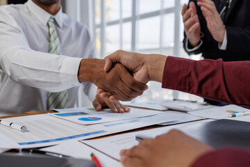 Close up of two businesspeople shaking hands after a deal contract is done.	