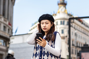 Young Asian Woman Walking and Using Smartphone in the City