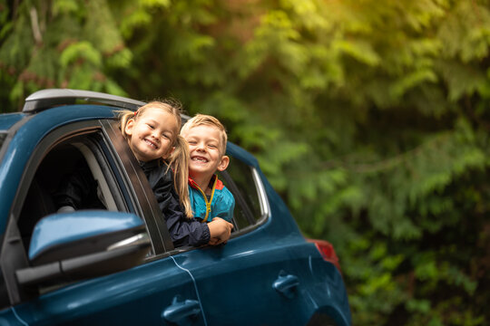 Portrait of happy little boy and girl in car. Family road trip, summer holiday travel concept.	